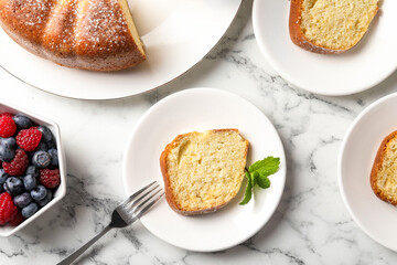 Freshly baked sponge cake, mint and berries on white marble table, top view