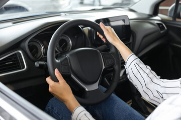 Young woman inside new car in salon, closeup