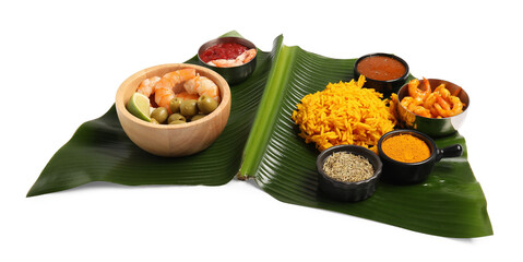 Piece of banana leaf with different food, spices and sauce isolated on white. Healthy eco serving