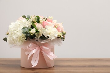 Bouquet of beautiful flowers on wooden table, space for text