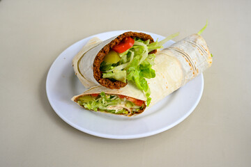 Cig kofte (raw meatball) with lettuce, tomato, pickle and lemon, hot Chee kofta. Turkish local raw food concept.Table scene of assorted take out or delivery foods. Doritoslu duble cig kofte durum.