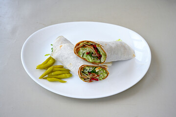 Cig kofte (raw meatball) with lettuce, tomato, pickle and lemon, hot Chee kofta. Turkish local raw food concept.Table scene of assorted take out or delivery foods. Doritoslu duble cig kofte durum.