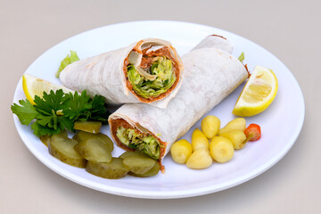 Cig kofte (raw meatball) with lettuce, tomato, pickle and lemon, hot Chee kofta. Turkish local raw food concept.Table scene of assorted take out or delivery foods. Doritoslu duble cig kofte durum.