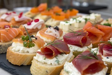 A close-up of a vibrant pile of assorted canap&eacute;s, featuring a variety of bite-sized appetizers with toppings like smoked salmon, cheese, and fresh herbs on crisp bases.