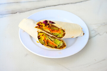 Cig kofte (raw meatball) with lettuce, tomato, pickle and lemon, hot Chee kofta. Turkish local raw food concept.Table scene of assorted take out or delivery foods. Doritoslu duble cig kofte durum.