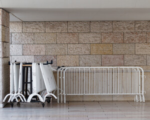 Crowd control barriers stored next to a wall.