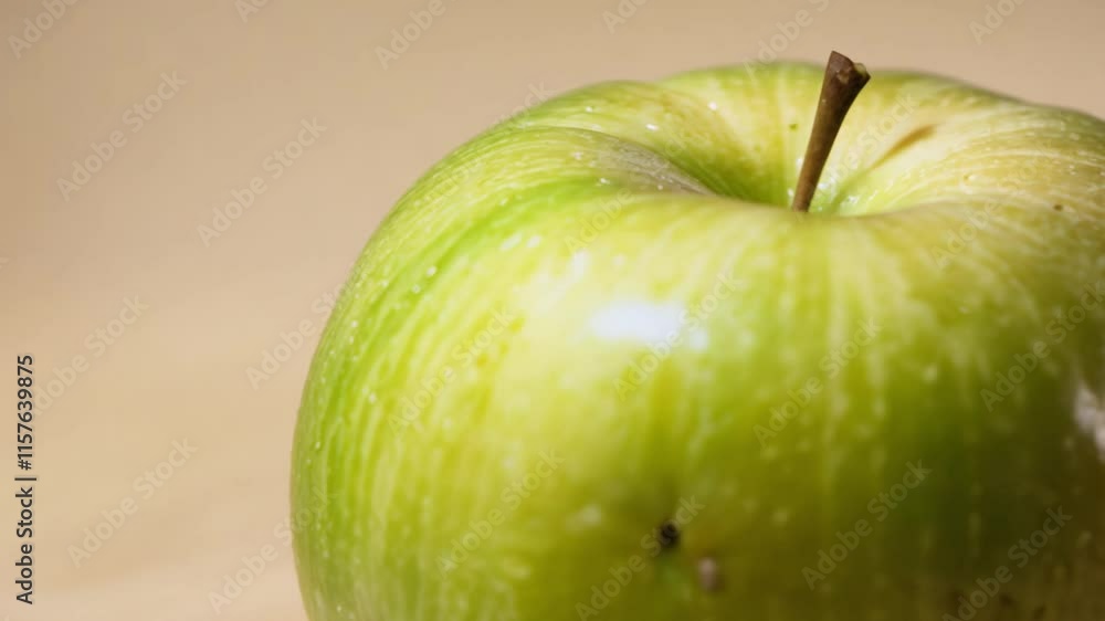 Aufkleber camera dollies in to reveal a single green apple resting on a soft beige gradient background with di