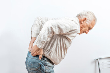 The older man grabbed his lower back. Radiculitis symptom, inflammation, pain in the spine of the...