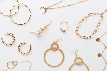 Elegant golden jewelry with decoration on color background, top view