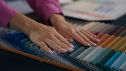 Close up hands woman girl touch soft fabric samples choose select cloth colorful palette design...