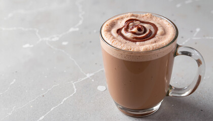 Chocolate frothy drink in glass cup on marble background