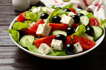 Delicious salad with feta cheese on wooden table, closeup