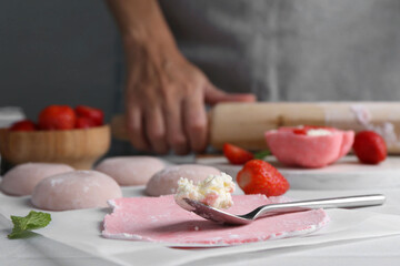 Woman making tasty mochi at table, closeup