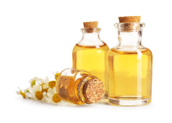 Bottles of essential oil and chamomile flowers isolated on white