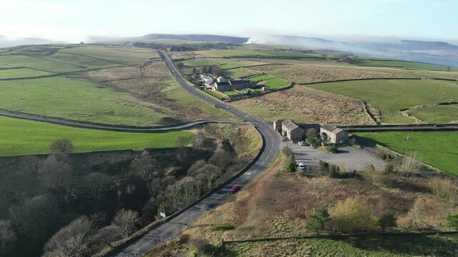 Aerial of vehicles driving on paved roads on Saddleworth Moor in Oldham, near Holmfirth, England