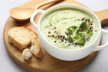 Delicious broccoli cream soup served on light table, closeup