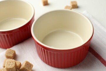 Ceramic casseroles and sugar cubes on table, closeup
