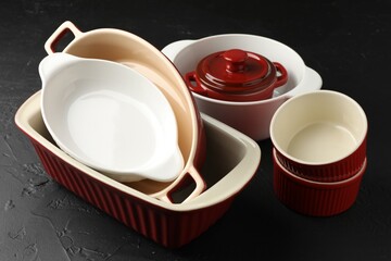 Many different casseroles on black table, closeup
