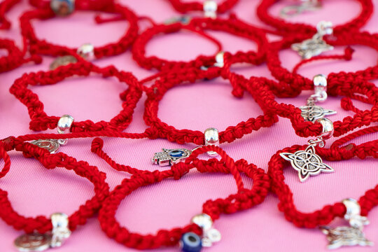 varias pulseras de siete nudos de hilo rojo, consideradas amuletos de protecci&oacute;n