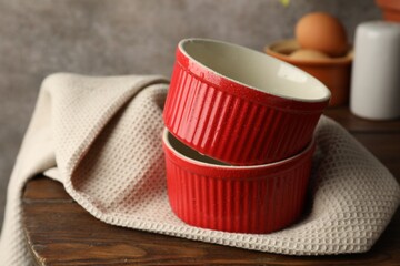 Red ceramic casseroles on wooden table, closeup