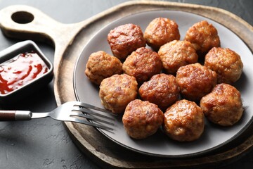 Tasty cooked meatballs served on grey table