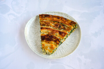 Turkish style meat stuffed filo dough borek served kol boregi.Cheese and minced pie are sliced on a marble background. Turkish name: Kol Boregi, kiymali, peynirli su boregi. Ci borek. Kafkas cig borek