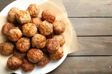 Many delicious meatballs on wooden table, top view. Space for text