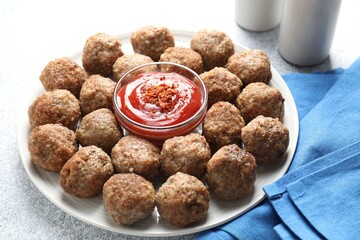 Delicious meatballs with ketchup and spices on light textured table, closeup