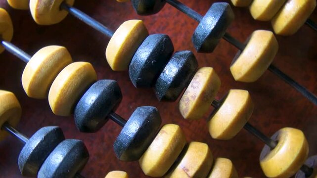 Old wooden abacus on wooden surface close up