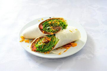 Cig kofte (raw meatball) with lettuce, tomato, pickle and lemon, hot Chee kofta. Turkish local raw food concept.Table scene of assorted take out or delivery foods. Doritoslu duble cig kofte durum.