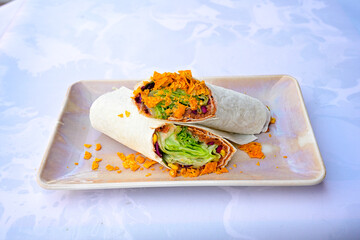 Cig kofte (raw meatball) with lettuce, tomato, pickle and lemon, hot Chee kofta. Turkish local raw food concept.Table scene of assorted take out or delivery foods. Doritoslu duble cig kofte durum.