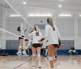 Volleyball players watching a hit on the right side against a weak double block
