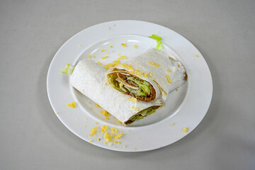 Cig kofte (raw meatball) with lettuce, tomato, pickle and lemon, hot Chee kofta. Turkish local raw food concept.Table scene of assorted take out or delivery foods. Doritoslu duble cig kofte durum.