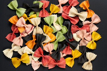 Close-up of colorful Italian farfalle pasta on a black background. Top view