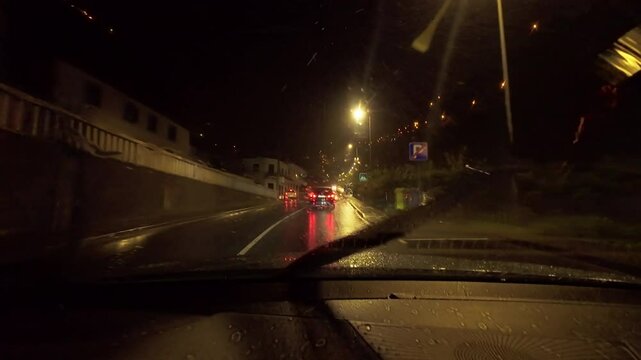 Night drive in rain bad weather condition. View from the car windshield to road