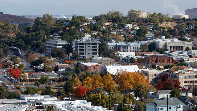 An 16x9 format image of the city of Martinez, California. The government buildings can be seen as well as an Amtrak train.