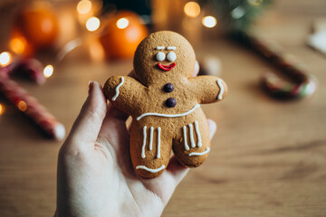Festive gingerbread man cookie held in a cozy holiday setting