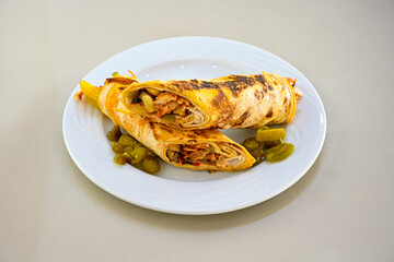 Lavash doner kebab ( soslu kasarli zurna doner durum )  or shawarma sliced in plate isolated.  Tavuk Et Doner Durum. Hatay Iskenderun usulu bazuka tavuk doner durum.