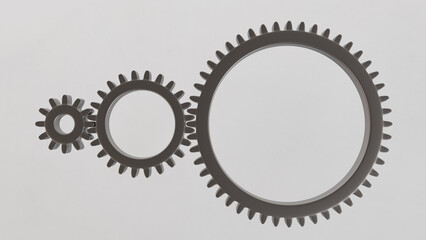 Three metallic gears in shades of gray, of different sizes, arranged in a line on a white background. Ideal for applications in engineering, industry, education and technical presentations.