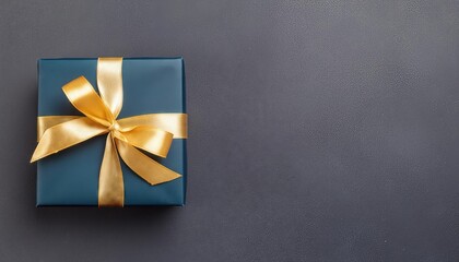 Elegant Dark Blue Gift Box with Luxurious Gold Satin Ribbon on Dark Background Perfect for Birthdays, Anniversaries, and Special Occasions Top View of a Stunning Present