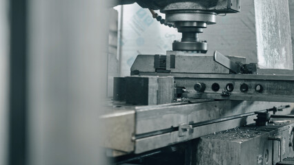 Close up view of a milling machine cutting through metal in a factory setting, highlighting intricate industrial manufacturing processes and the precision of modern engineering techniques