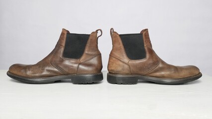 Polished men`s old shoes stand turned in different directions.