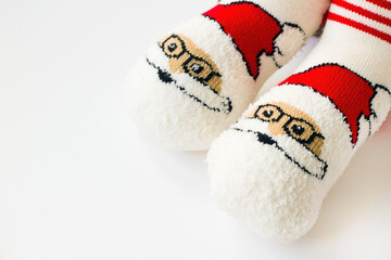 Santa Claus themed,red and white colored winter children's socks on white surface with copy space