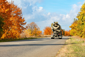 Autumn landscape with a concrete truck traveling down a rural road
