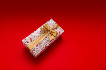 The wrapped gift should be on a bright red background with a gold ribbon, a gift for a birthday,...