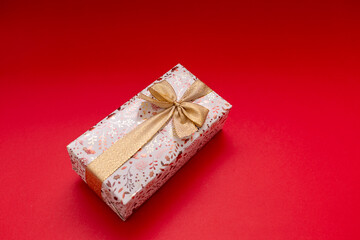The wrapped gift should be on a bright red background with a gold ribbon, a gift for a birthday,...