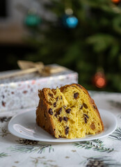 Italian pie with chocolate and dried fruits, traditional Christmas dessert against the background of a decorated Christmas tree