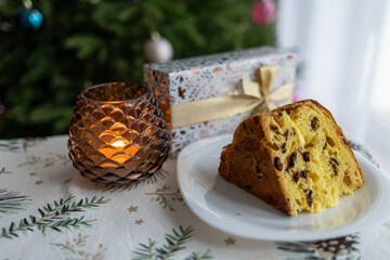 Italian pie with chocolate and dried fruits, traditional Christmas dessert against the background of a decorated Christmas tree