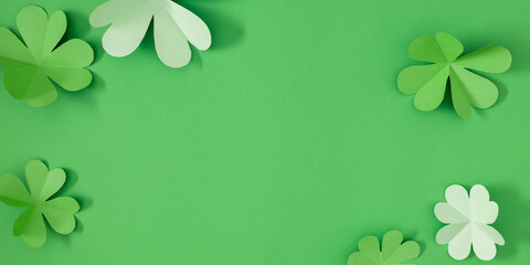 St Patrick's Day four leaf clover on green background. Patrick's Day composition, banner. Four-leaf clover paper art. Top view. Flat lay