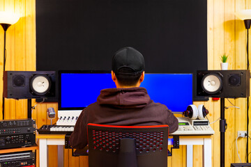 back of asian professional music producer, composer, sound engineer, musician working in home recording studio